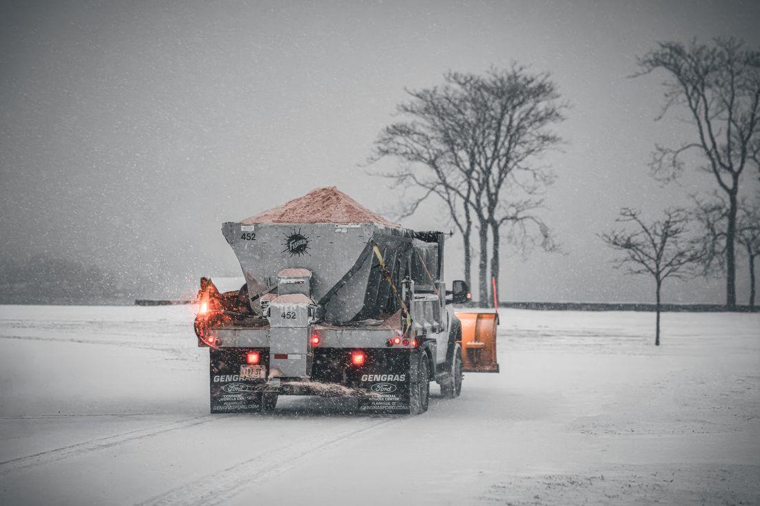 A truck spreading salt on a snowy road